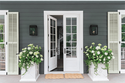 Symmetrical details like the tall potters and double mats help complete this entryway featuring French doors from Marvin.